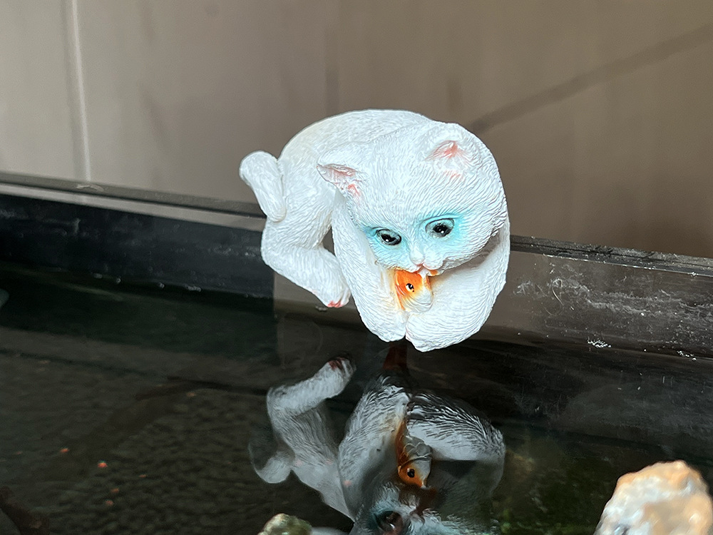 Котенок держит белую рыбу