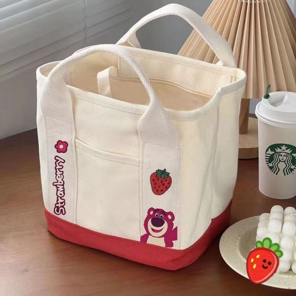 A small handbag is carried by a female student going out. She is carrying a 2024 new style bag, a mini canvas bag, and a Korean version bento bag for female students undefined