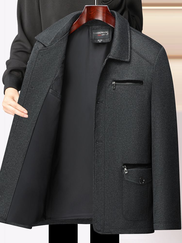 秋冬の中高年のメンズとベルベットのコートのお父さんはビジネス服の中年の男性の厚いジャケットの上着を襟を返します。