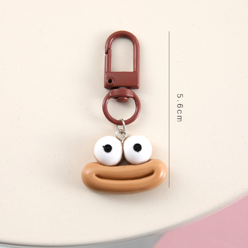 かわいいアニメの大きな口のキーホルダーは学生のカバンを飾っています。