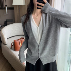 グレーの偽の2つのvネックのニットのカーディガン秋冬の女性のデザイン感の小さい大衆のフランスのゆったりしている短い長袖の上着