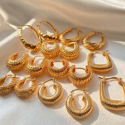 Elegant, heavyweight-inspired ear clips with a textured, premium feel—featuring a retro-style oval copper tube design plated in 18K real gold and boasting a distinct granular texture.