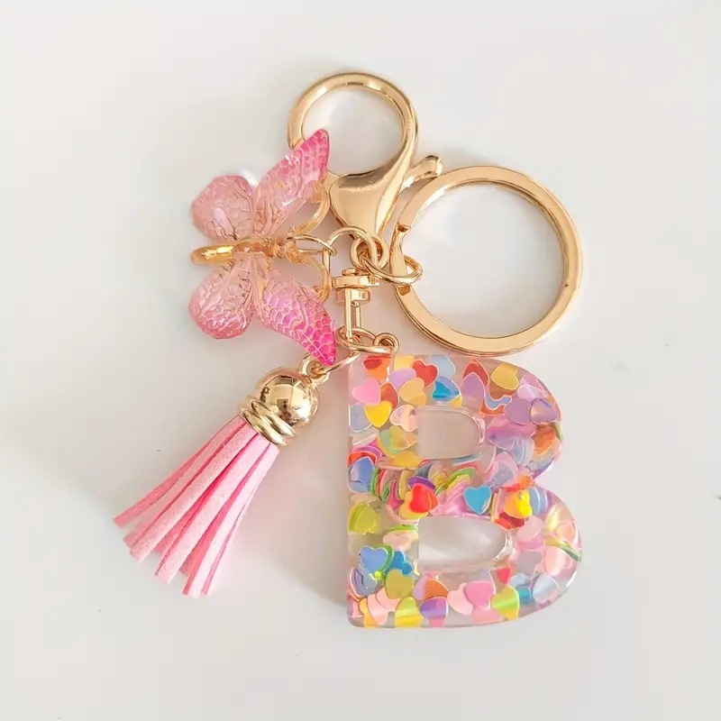 2024 transfronteriza en stock resina rosa con lentejuelas 26 letras inglesas llavero colgante mariposa borla Accesorios