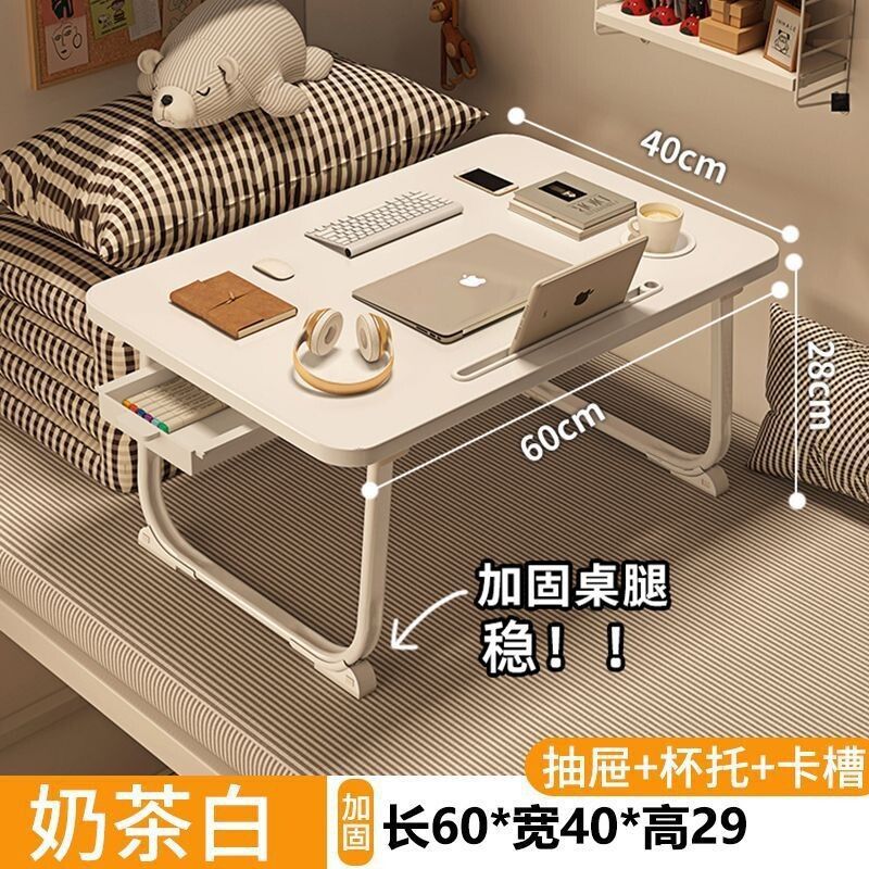 ベッドの上の小さい机のノートパソコンの机の上で折り畳みます。|undefined