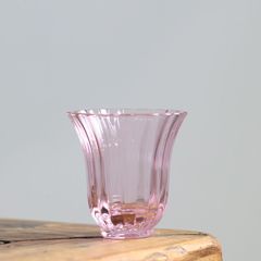 創意的なピンクの花は香りの杯を嗅いで香りを集めます。女性はお茶を飲みます。