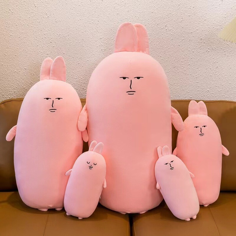 爆発的なピンクのウサギの長いバーは枕のベッドの上で足のぬいぐるみの女の子のプレゼントの子供のプレゼントの卸売りを挟みます。|undefined