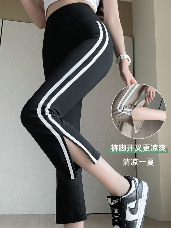 白い辺のサメのラッパのズボンの女性の外は夏の薄い金の小さい背の八分の腰を着てフォークを開けます。|undefined