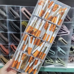 創意的な趣味の子供のヘアピンは少女のタバコの前髪をいじります。