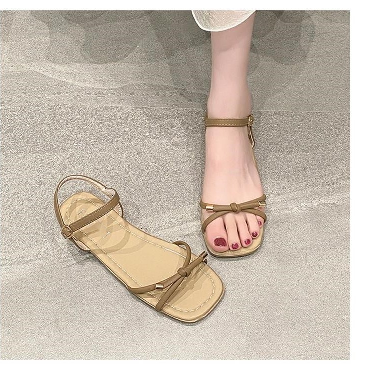 Arco sandalias planas para mujeres verano 2026 nuevo estilo con una sola línea suave de hadas estilo versátil no cansado zapatos de viaje