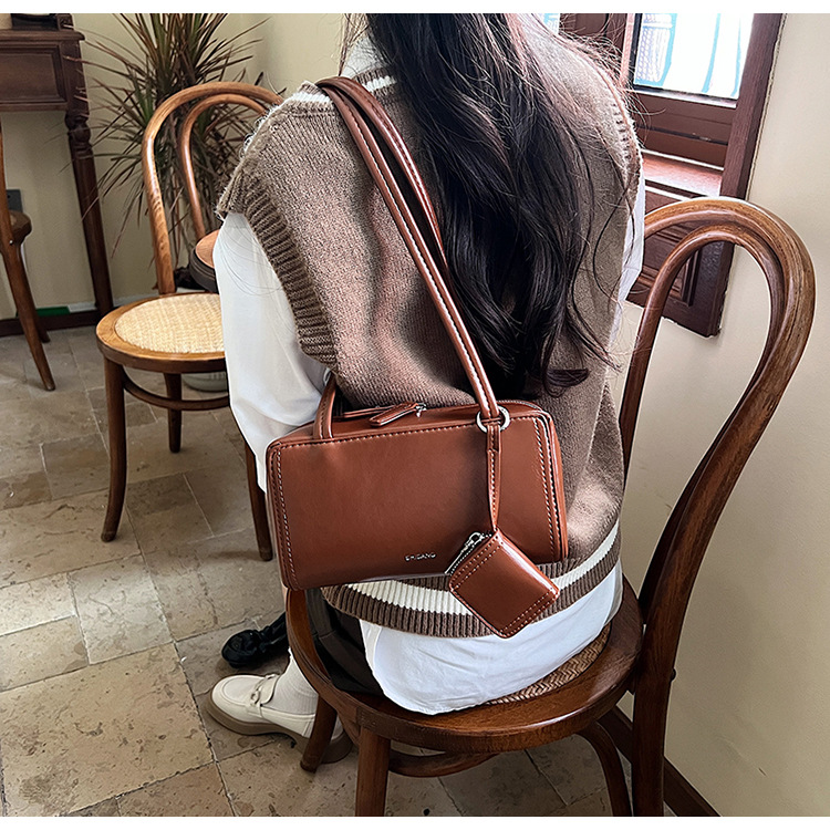 The 2024 new women's single-shoulder underarm bag is a simple and elegant commuting bag with a Korean-style niche design sense. It's a small square bag undefined