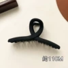 Black and fibrous clip about 11cm long