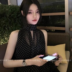 夕暮れの光のストラップは首の袖のない波点のシフォンのシャツの女性のフランス式のお姉さんの高級感のゆったりした上着を掛けます。