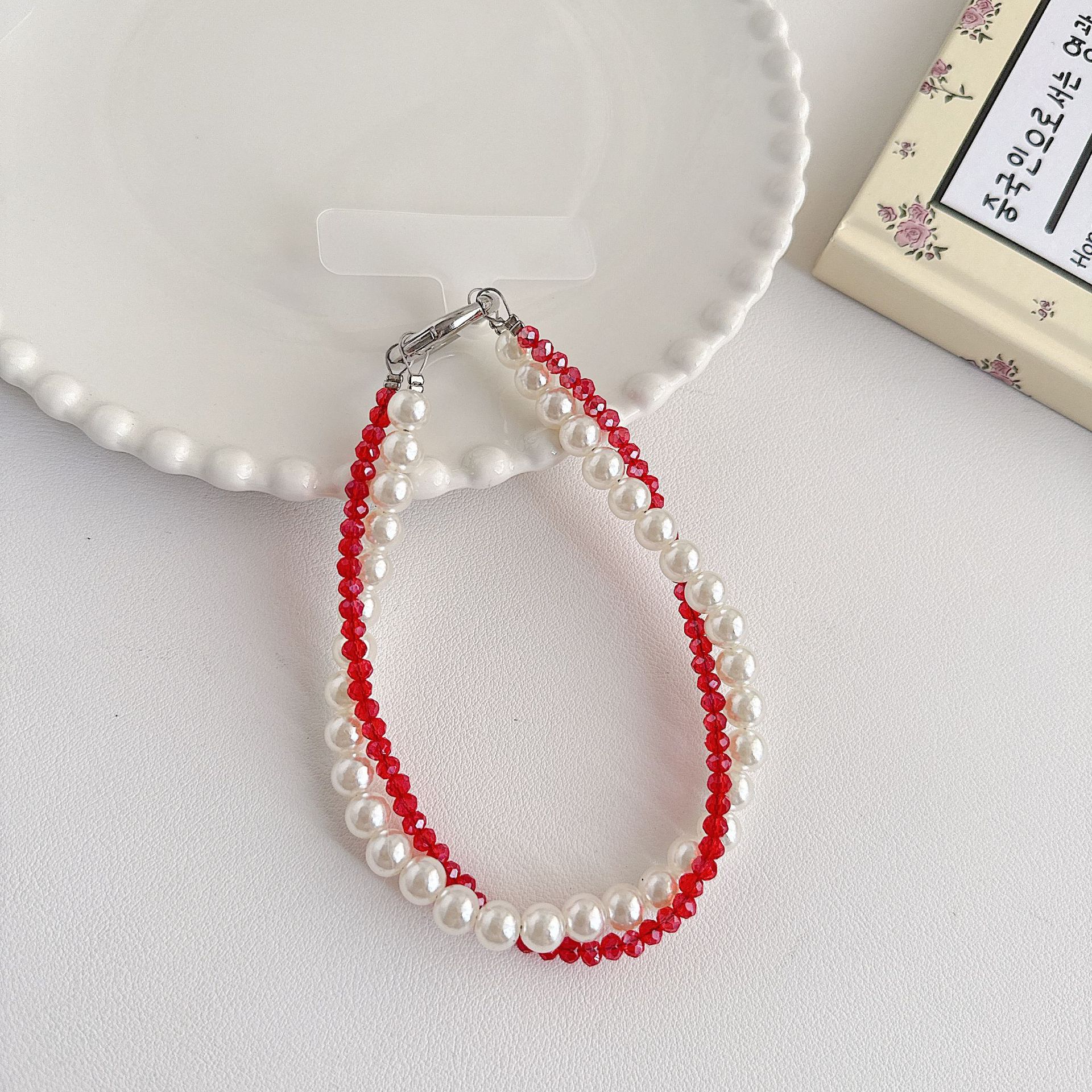 Boutique hecho a mano de alta gama teléfono móvil cadena colgante mujer estilo ins cristal coreano perla enrollamiento cadena de muñeca moda corta