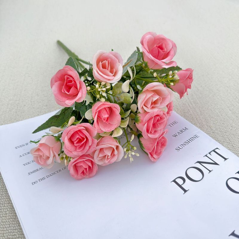 模造花ミニバラは花を手にして家にいる結婚式の室内客間の装飾に造花を飾っている|undefined