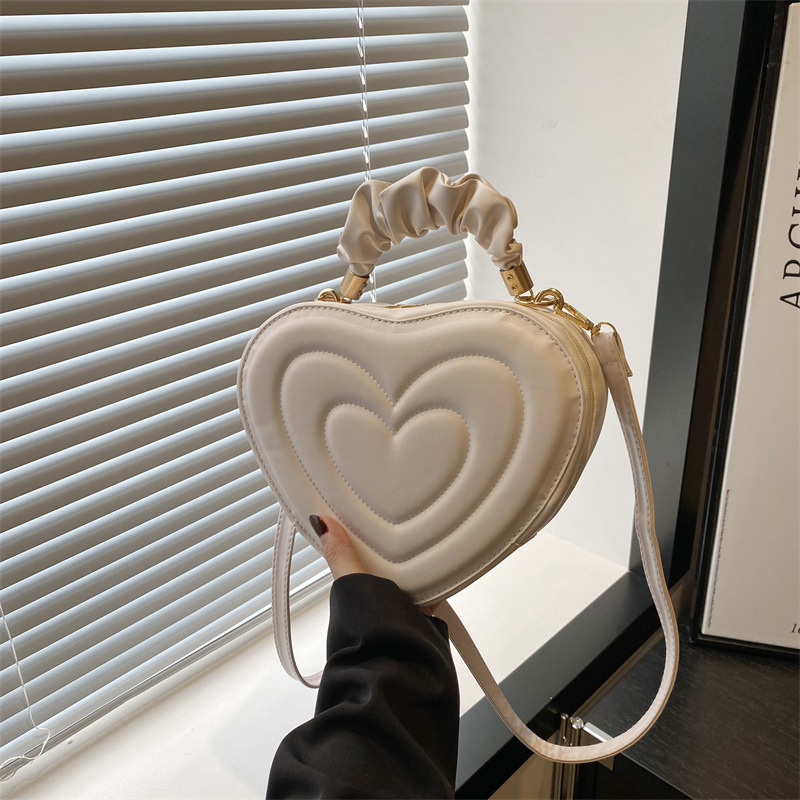 2024 otoño y invierno de mujeres nuevas caramelo de cáscara dura bolso de hombro de color corazón bolso de moda bolso de amor amor amor impresión
