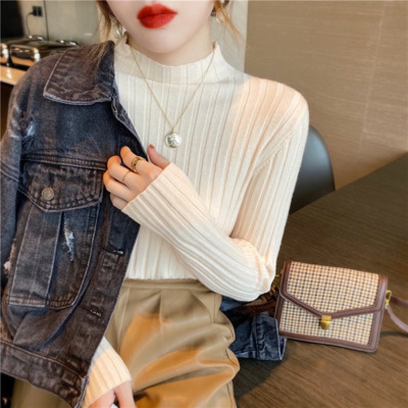 坑条半高襟のカーディガンの中にセーターを着ています。