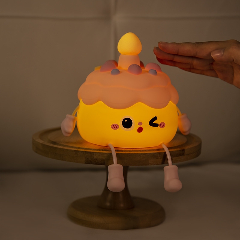 創意的な誕生日ケーキの小夜灯のベッドの上に飾られています。|undefined