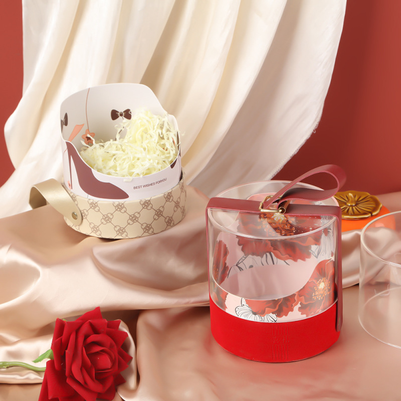 半透明の円筒を手にして手に入れるギフトボックスはシンプルで贅沢な結婚花嫁の喜糖箱花アクリル包装箱である|undefined
