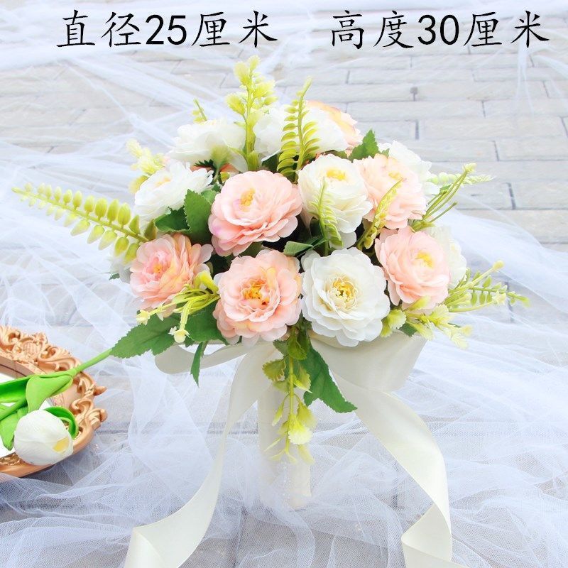 手に花を持つ新婦の韓国式結婚式の領収書のシミュレーションの花束の森系のウェディングドレスの撮影の道具の手に花をささげます。|undefined