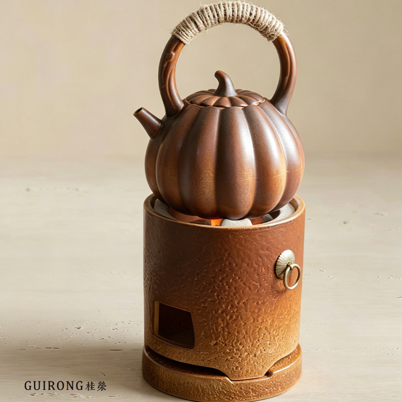 Rustic ceramic pumpkin teapot with handle and charcoal stove set for tea brewing by the fire. Vintage tea brewing stove for home use, suitable for indoor and outdoor use
