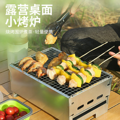 屋外キャンプのテーブルの上の小さいオーブンの囲炉裏はお茶を煮てストーブを焚いてストーブを焼きます。