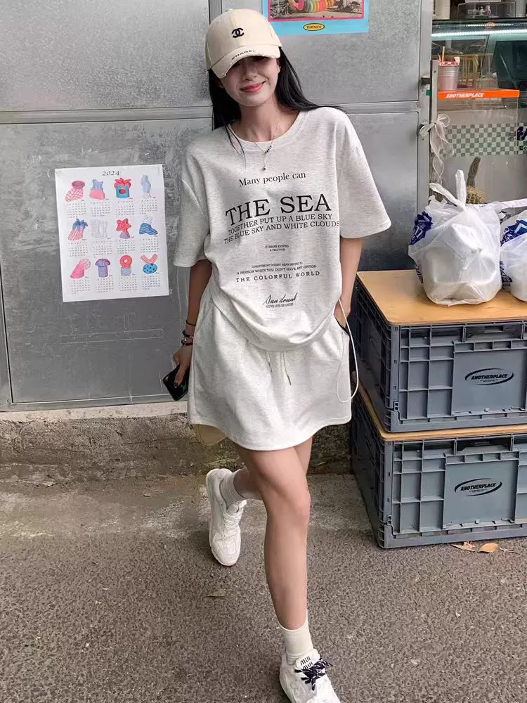 Повседневный спортивный костюм в корейском стиле для женщин летом, свободный и уменьшающий возраст, юбка-трапеция с короткими рукавами и завязками, модный комплект из двух предметов.