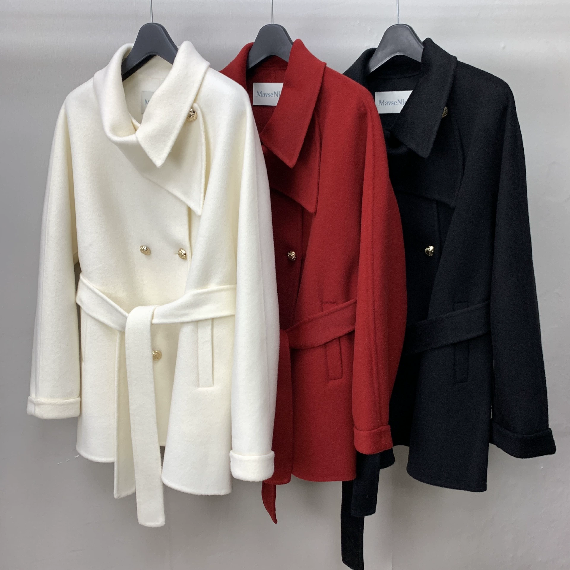 Короткое двустороннее шерстяное пальто средней длины с черно-белой и красной металлической пряжкой в стиле накидки на зиму 2025 года.