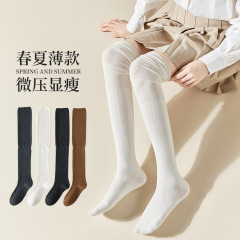 膝を通す女性の夏の薄いタイプの白黒の純色は長い筒をつづり合わせて靴下の滑り止めの純色の潮流を積みます。