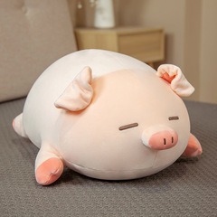 コブタのぬいぐるみのクッションが柔らかい萌え枕を抱いて寝ているベッドの少女の心がかわいいベッドの頭が枕をなだめている