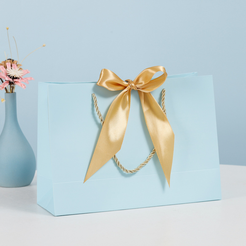 Bolsa de regalo de lazo Bolsa de papel Bolsa de embalaje de ropa Bolsa de cosméticos al por mayor Bolsa de compras Bolsa de mano con logotipo impreso