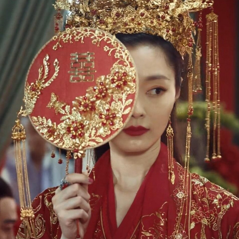 中国式の結婚式の秀禾の顔の団扇の震え音の赤い本の新婦の結婚する手は花の古風をささげて結婚します。|undefined