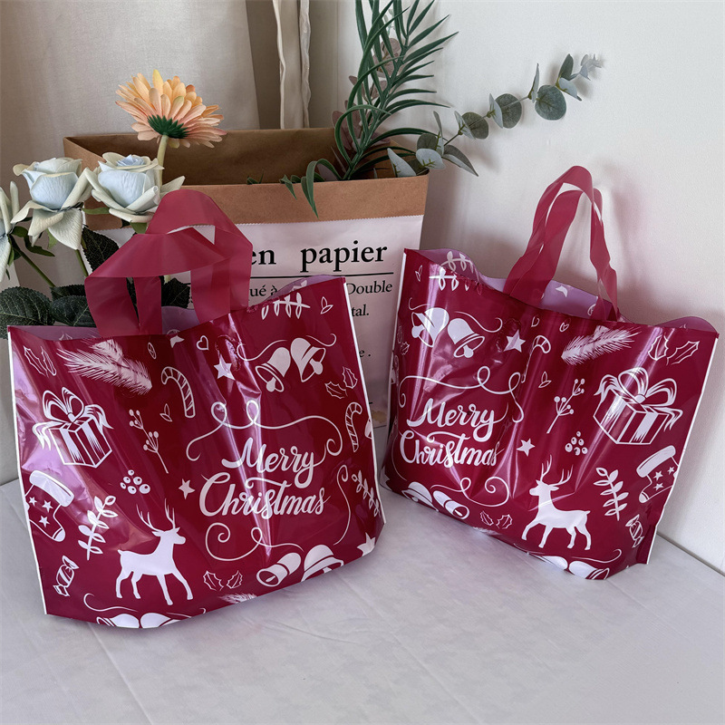 クリスマスの祝日の赤い厚手のプラスチックの贈り物の服の店は手提げの袋の包装で厚い買い物をして祝い事を包装します。|undefined