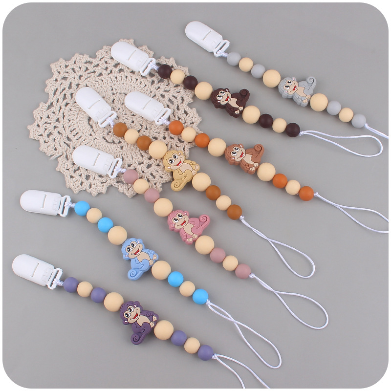 Nuevos suministros para bebés mono de dibujos animados mordedura de chupete de silicona lindo bebé creativo cadena anti-gota cadena
