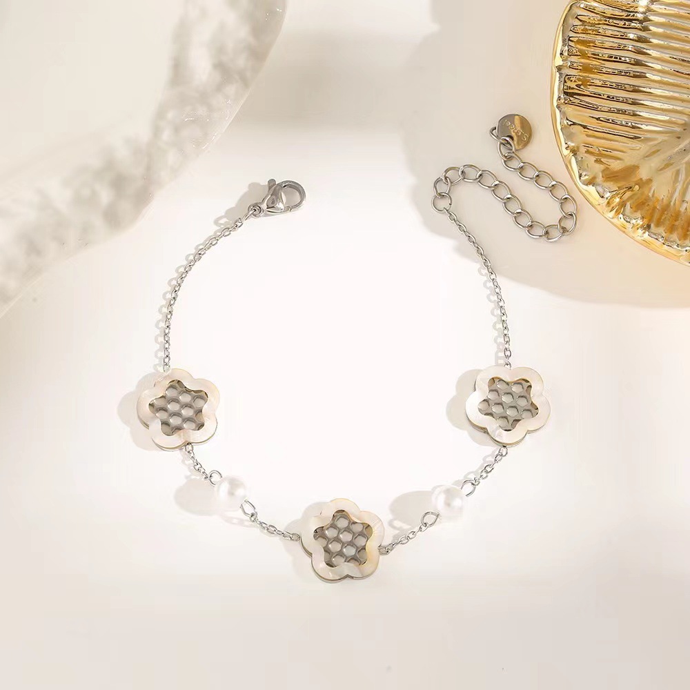 Pulsera de trébol de acero titanium vendedora caliente transfronteriza europea y americana con incrustaciones de concha pulsera colgante pulsera de diseño avanzado sin desvanecimiento al por mayor