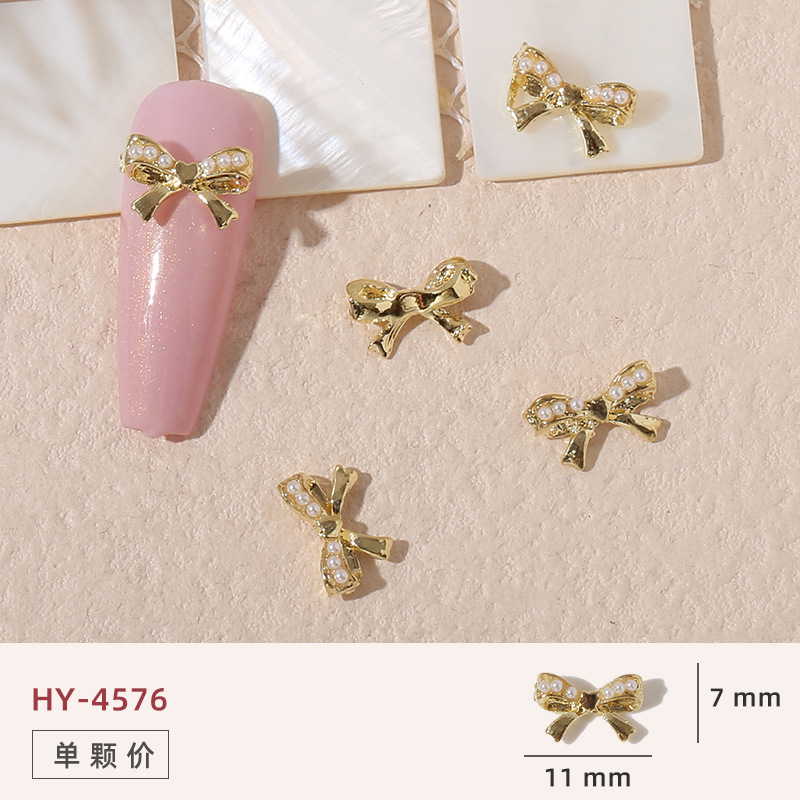 Uñas mariposa joyería nueva línea popular perla arco metal decoración de uñas pequeños accesorios de joyería al por mayor