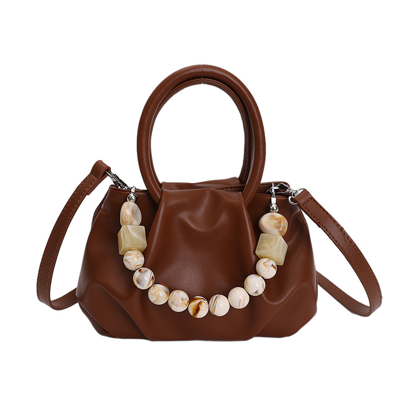 Alta sensación de mano pliegueada nube bolso de cubo para mujeres 2026 nuevo nicho de lujo ligero de moda perla bolsa de mochila