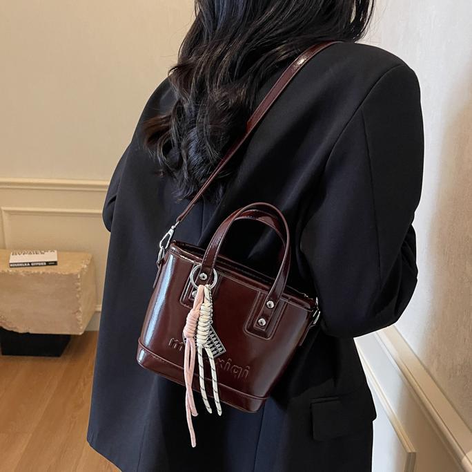 Retro brillante bolso de cubo de mano 2025 nuevo estilo bolso de hombro de color contrastante sensación de alto nivel bolso de mochila casual simple