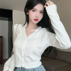 ニットのカーディガンの外は女性の春秋の薄いタイプのセーターのオーバーの底のシャツに合わせてvネックの短いタイプの上着を掛けます。