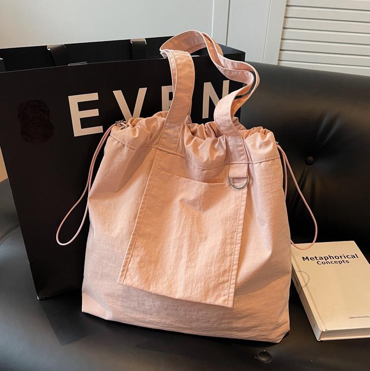 Bolsa de tela de nylon impermeable para mujeres 2025 nuevo tipo bolso de cubo de viaje ligero de gran capacidad bolso de hombro portátil para estudiantes universitarios