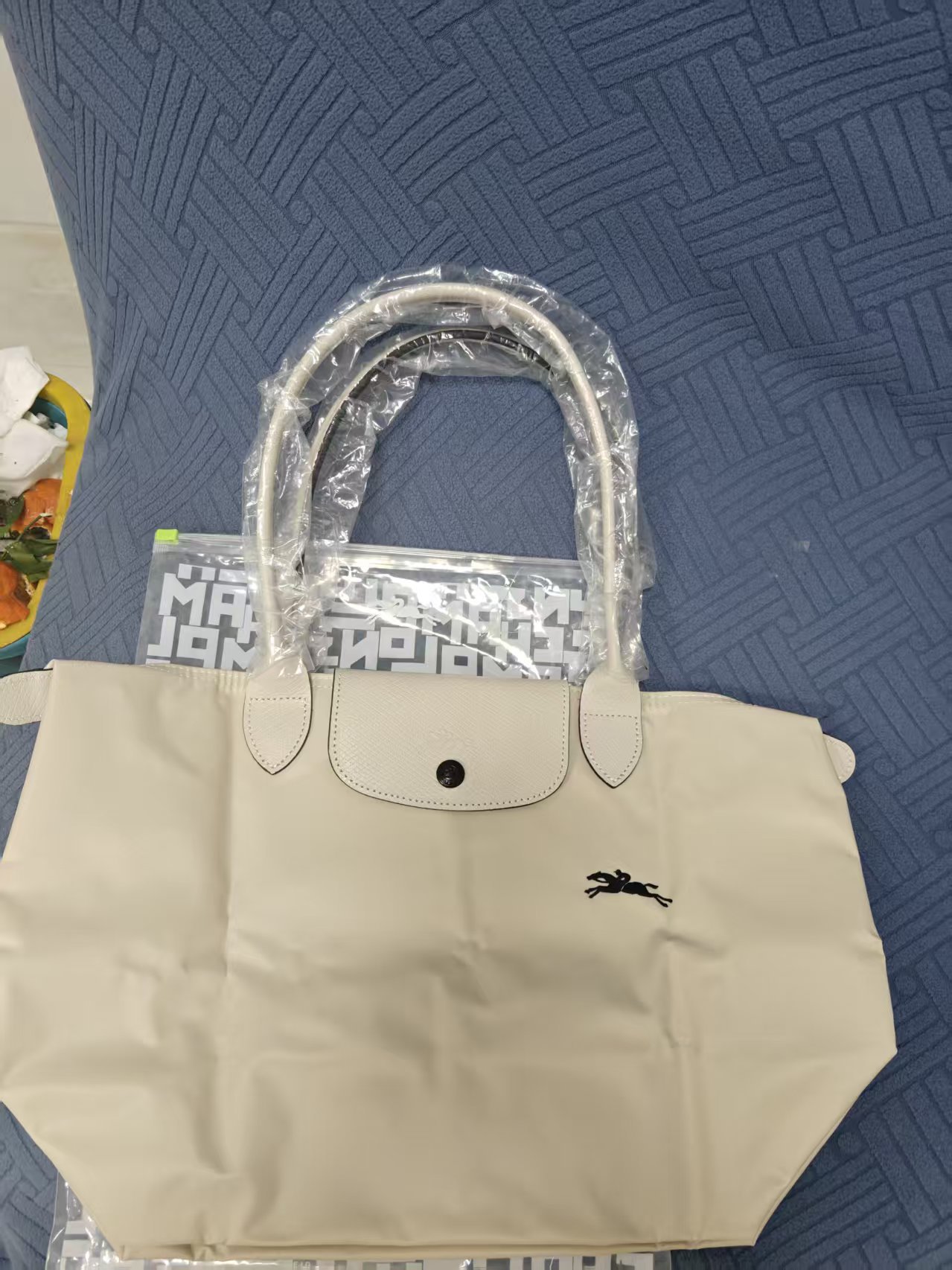 フランスの竜は高く上げてナイロンのカバンを包んで、女性のカバンの長い柄はギョーザの包みを持って折り畳みます。