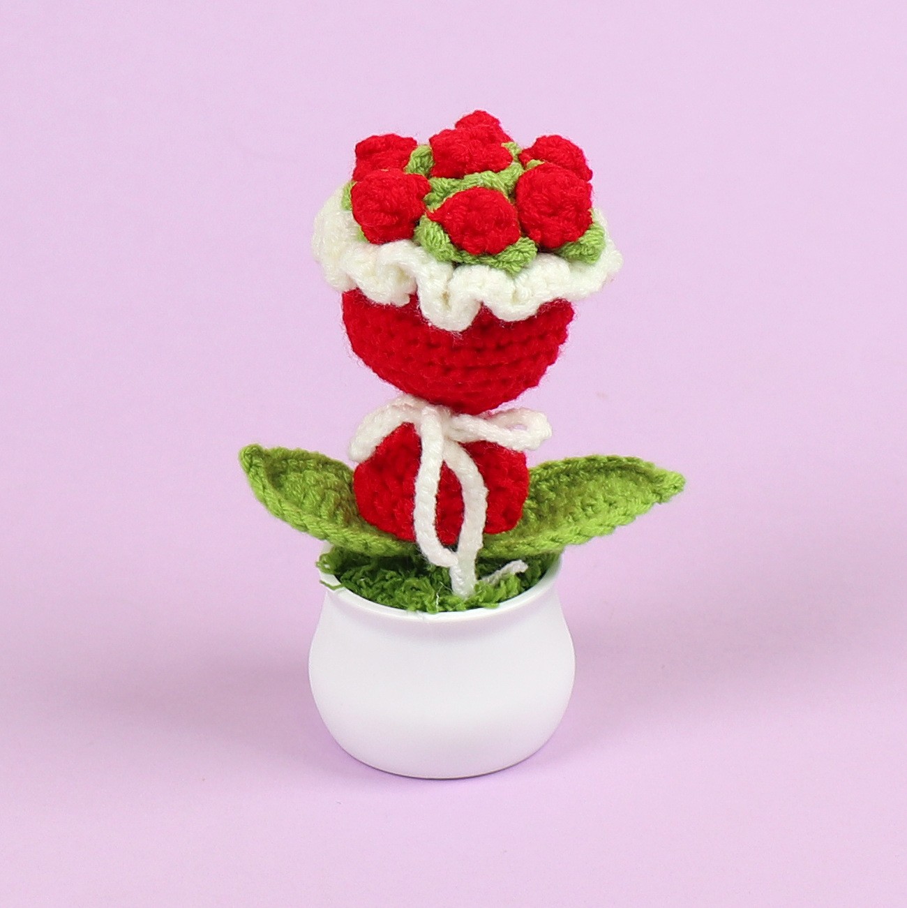 Macetas de flores rojas en la mano