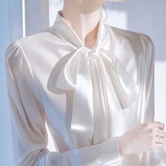 フレンチリボンの白いサテンのシャツの女性2025早春の新型のハイエンドの中に長袖の職業のシャツを掛けます。