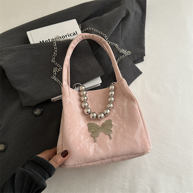 Alta sensación de lujo ligero bolso de cubo axilar 2024 verano nuevo estilo de moda arco de cuentas cadena de hombro mochila