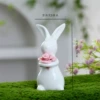 Pink rabbit holding flower in hand