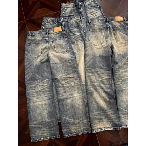 Vintage punk-style straight-leg, low-rise, slightly flared denim trousers with embroidery and a flowing, relaxed fit.