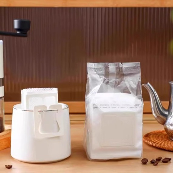 コーヒーろ紙の耳のろ紙の手でコーヒーの粉の濾過紙を流します。
