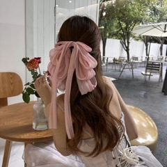 超仙の蝶結びのリボンは女性の半髪のポニーテールのクリップを挟んで顔を見せます。