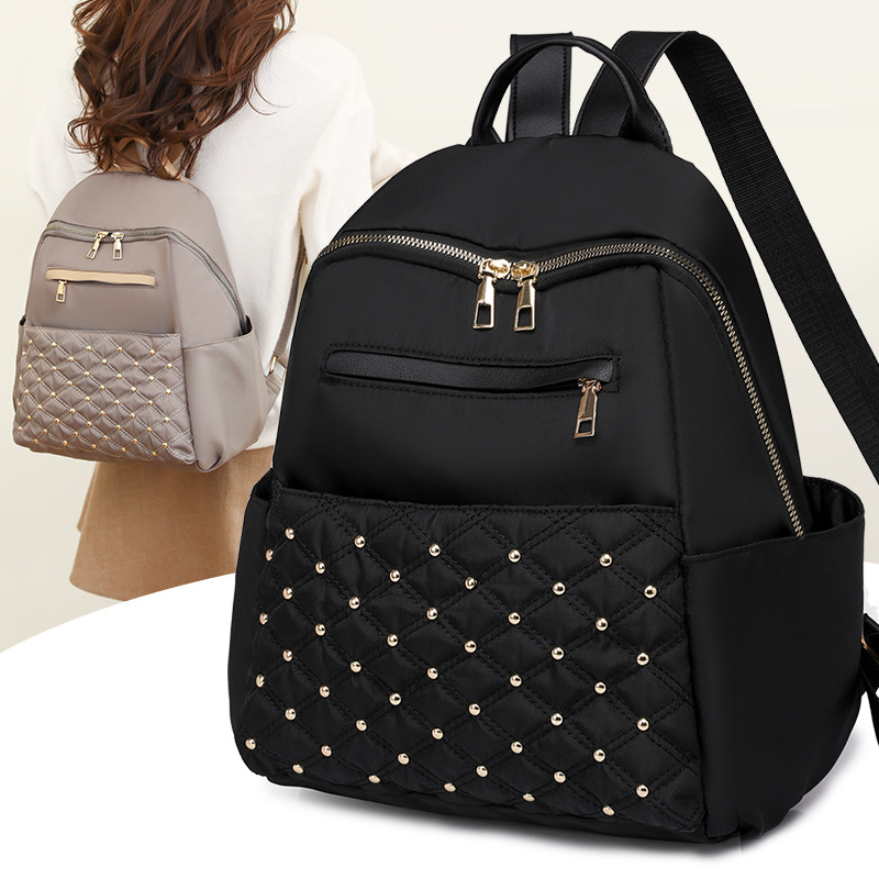 2023 nueva mochila de nailon para mujer coreana, remache de diamantes de moda, mochila de viaje de cercanías de gran capacidad al por mayor