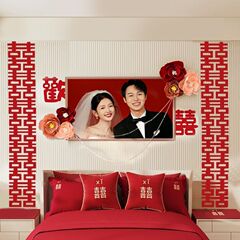 結婚部屋にウェディングドレスを飾って男女側の新しい部屋のベッドの上のお祝いの字の寝室の壁の喜字の花の卸売りを飾ります。