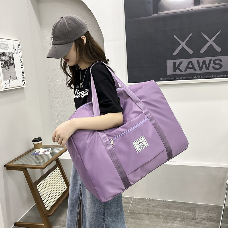 旅行鞄旅行寮の大容量ハンドバッグの荷物バッグを持っています。|undefined